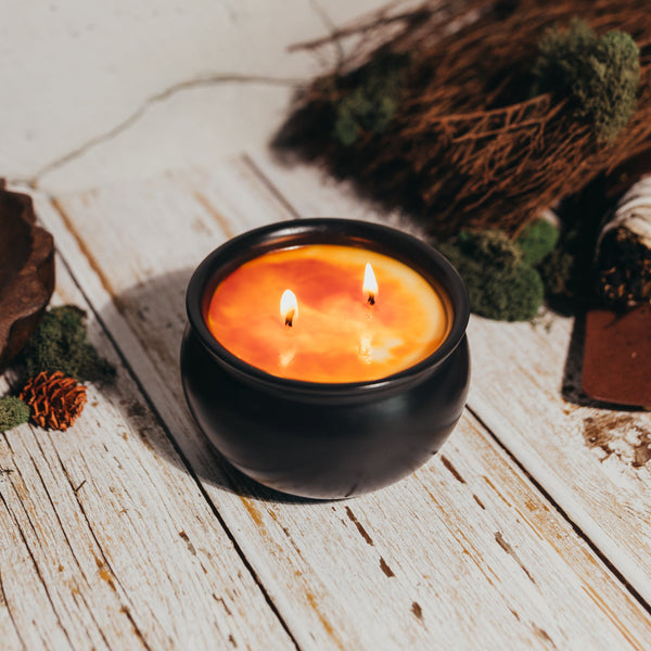 Candle in a black holder with decorative elements on a wooden surface