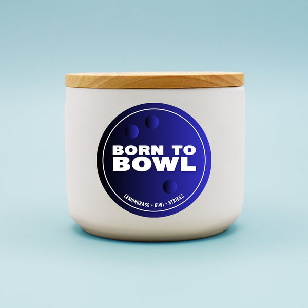 White bowl with a wooden lid and 'Born to Bowl' label on a light blue background