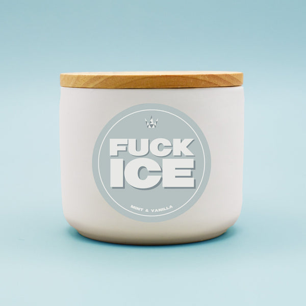 Candle jar with a wooden lid and 'FUCK ICE' label on a light blue background